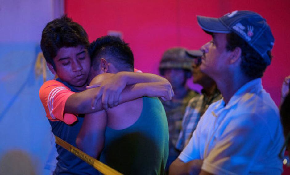 Dos jÃ³venes se abrazan frente al bar donde se desatÃ³ el incendio. (foto: Reuters)